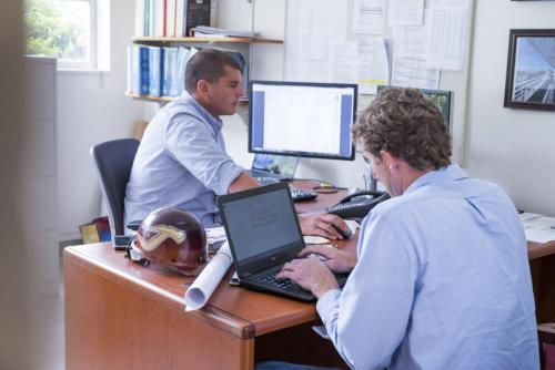 2 men working on computers at a desk