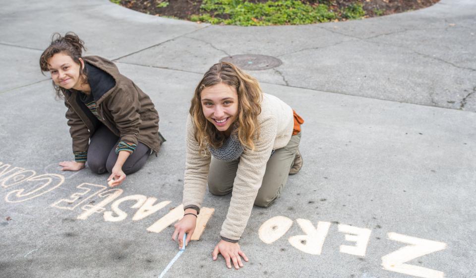 Students from the WRRAP write in chalk on campus walkways to advertise for their annual Zero Waste Conference. 